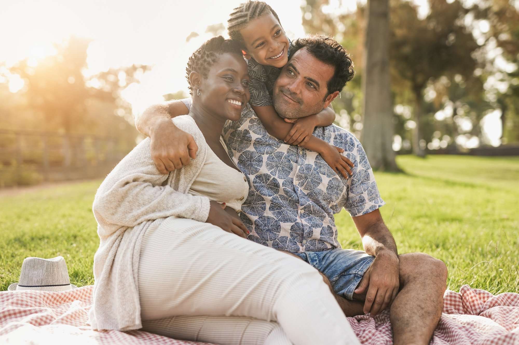 Happy multiracial family hugging each other at city park
